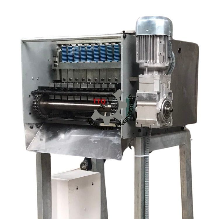 Close view of a TTQ 10 Head cutting deck showing stations, chain drive and blade carrier