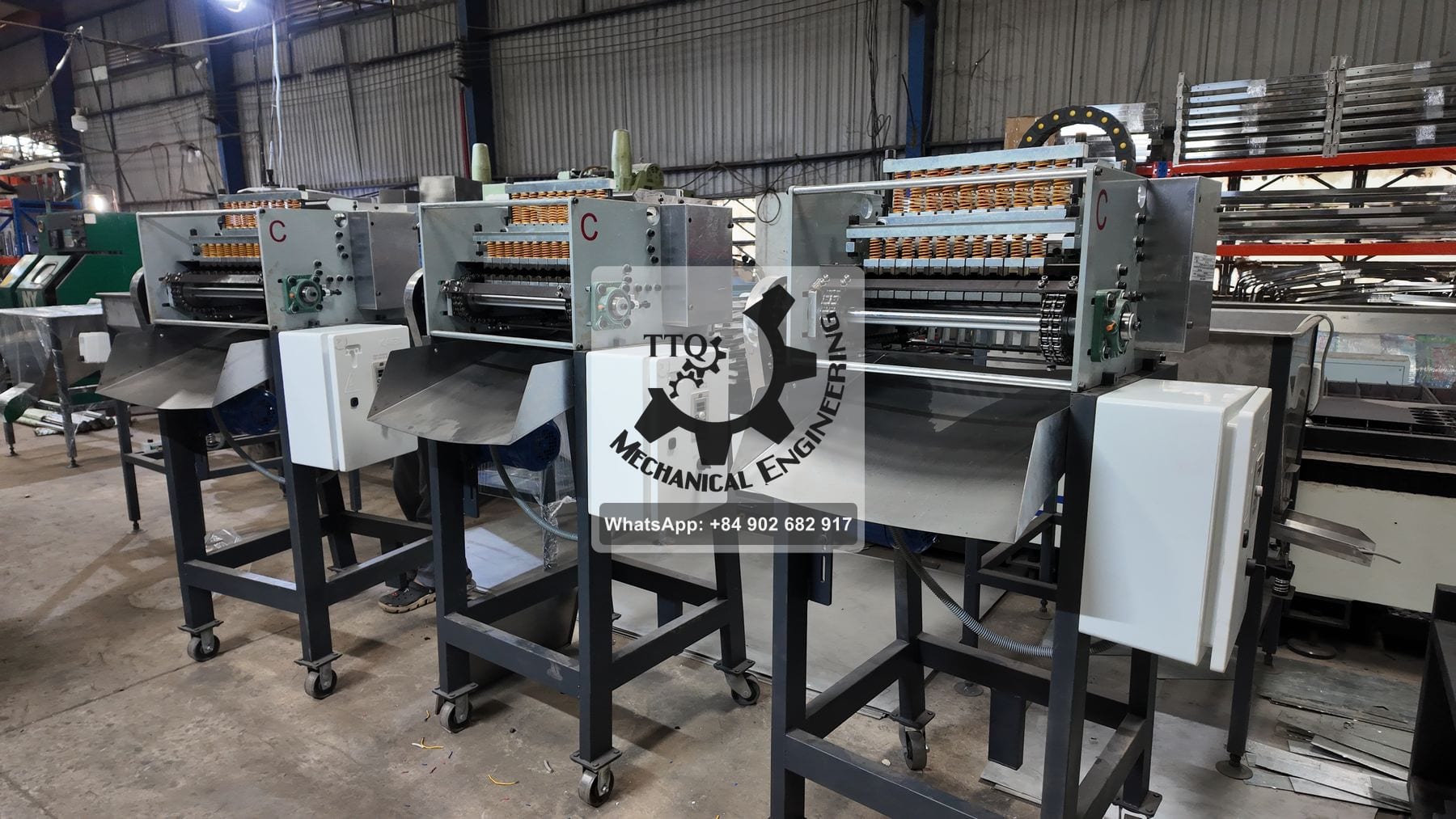 Cashew cutting machines in build, each on a wheeled stand with its own electrical control box