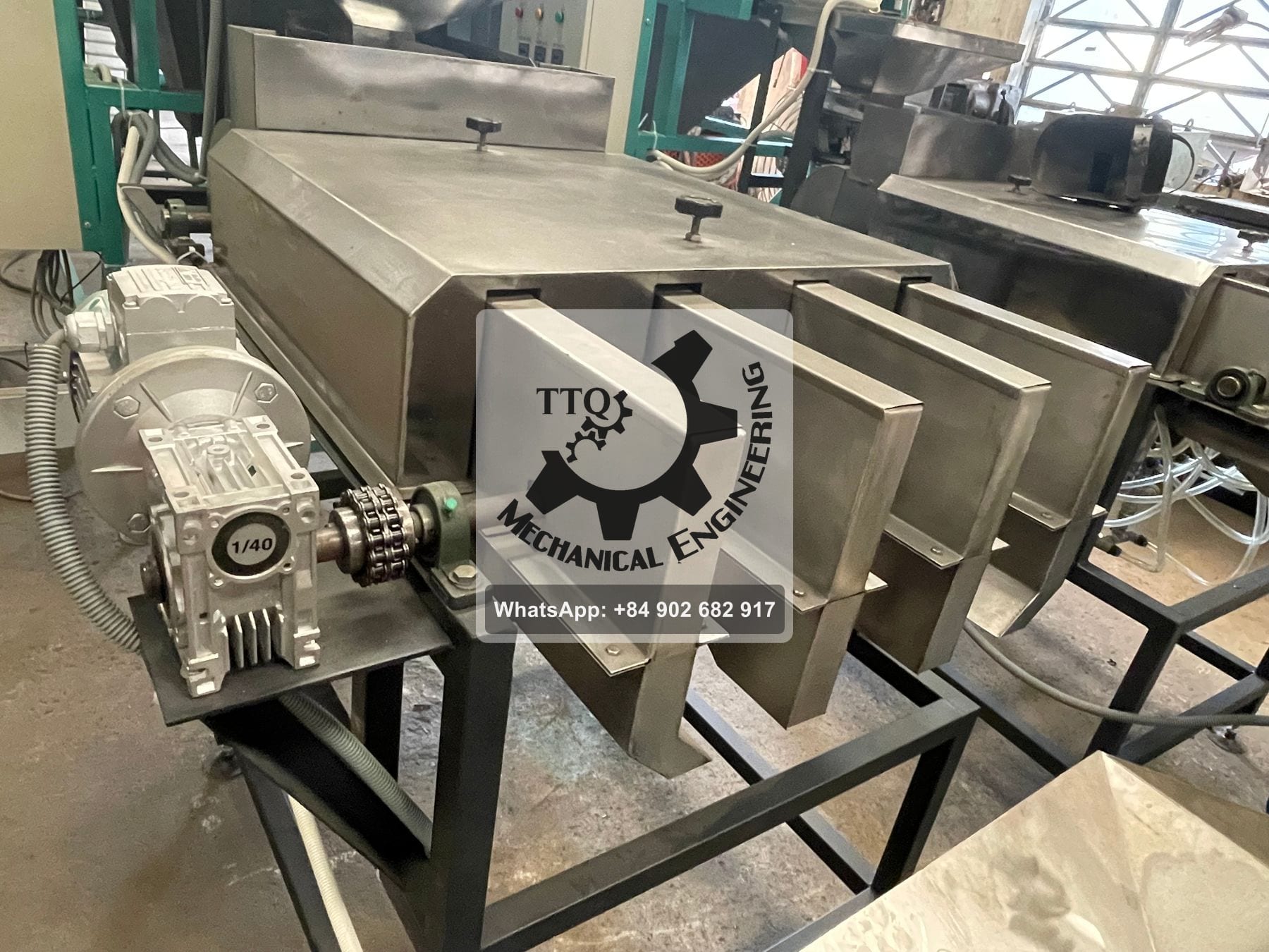The four-outlet discharge section beneath a peeling machine, with geared motor and chain drive